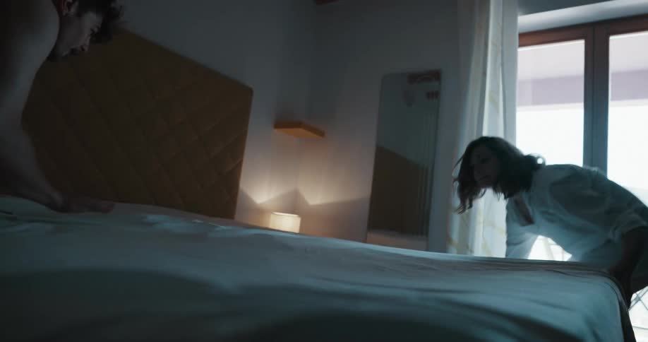A man and woman making a bed