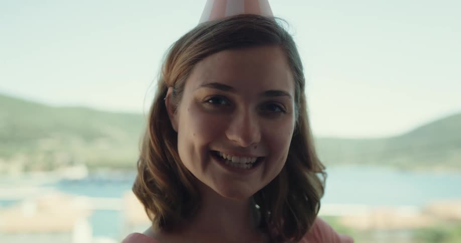 A woman wearing a party hat laughs
