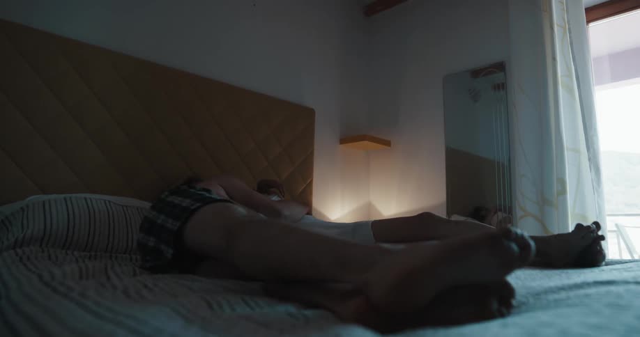 Young couple making the bed before laying on it to cuddle