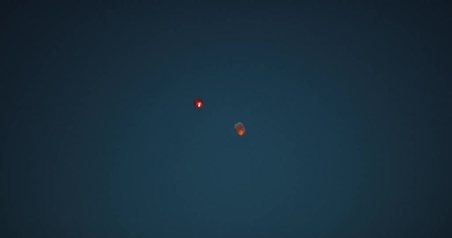 Two lanterns with fire floating in the sky