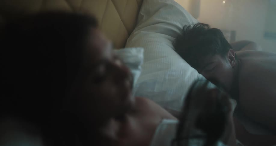 Husband and wife are laying in bed together and sleeping