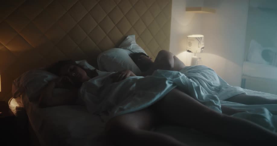 A view of two people sleeping in a bed