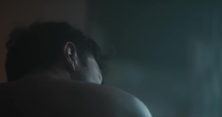 A man is sitting in his room at night