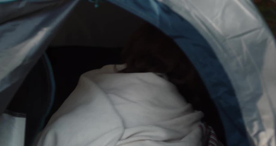 A woman kisses a man in the tent