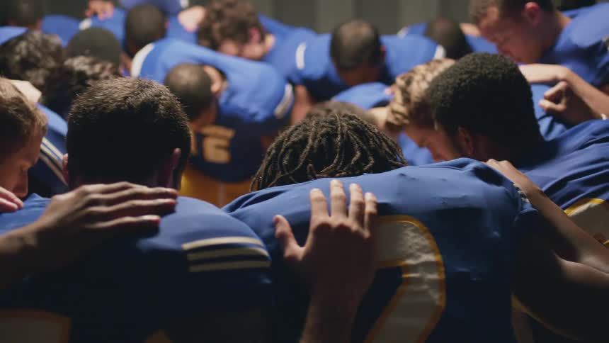 Football players gathered in a huddle