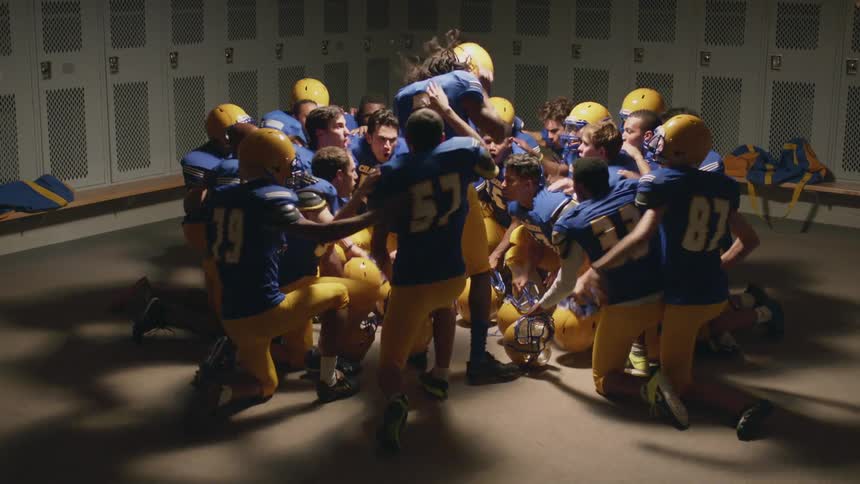 Young football team celebrating in a locker room