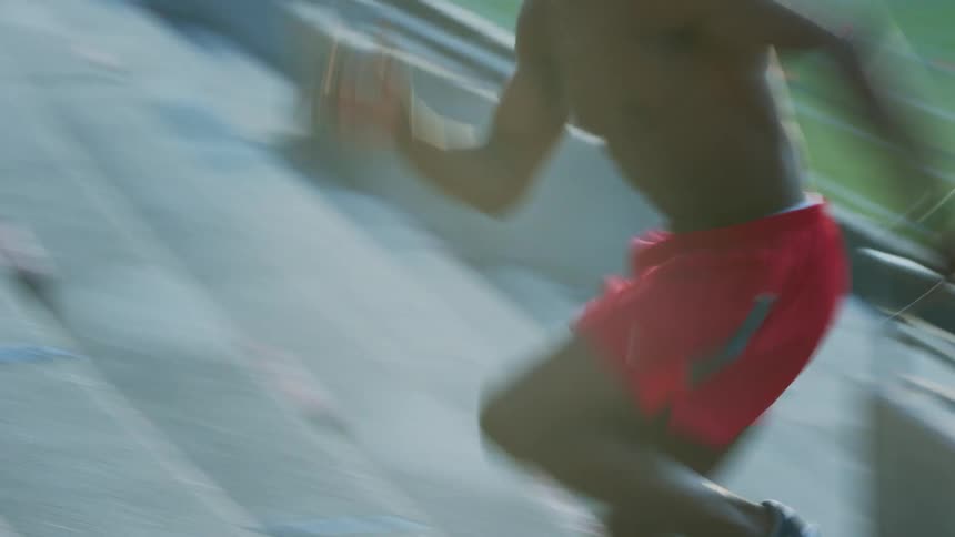 A man running up the stairs in a football stadium