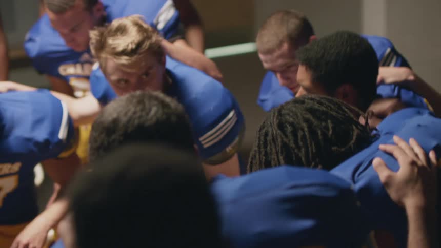 Football players rallying in a locker room