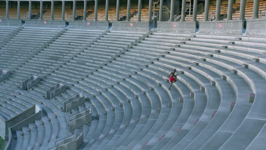 Man running up seats in an empty stadium