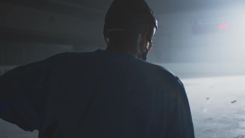 A man standing in a hockey arena