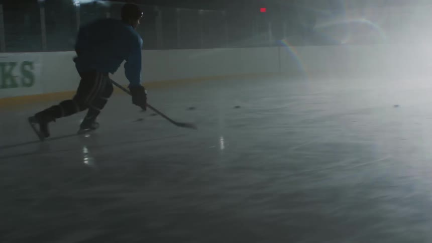 An ice hockey player practicing his shot