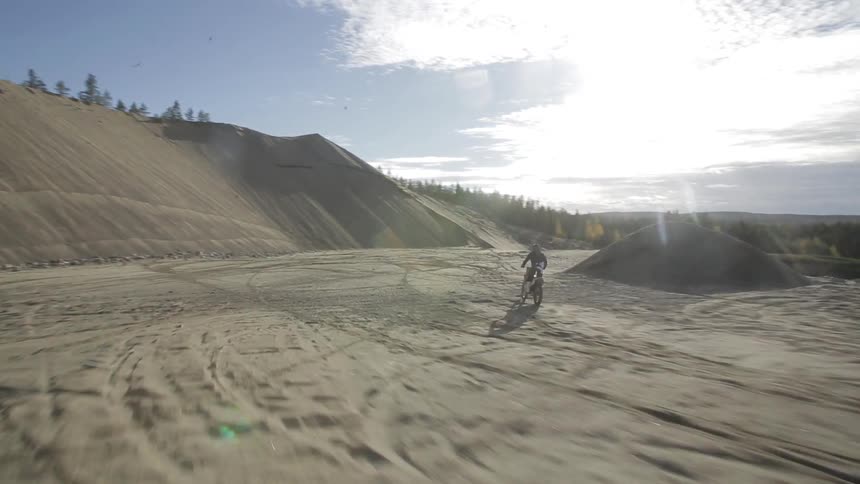 A person on a motorcycle rides a dirt track