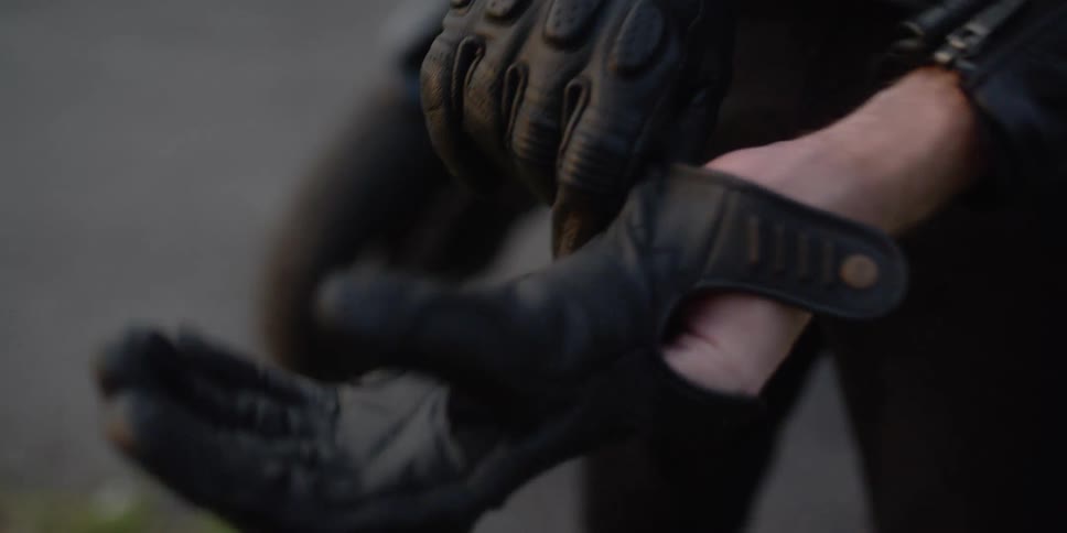 A person that is putting on gloves outdoors