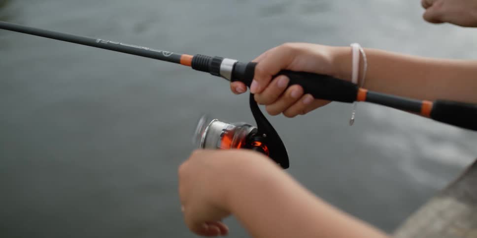 Two people are fishing in a lake during the day