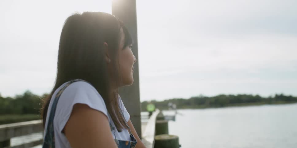 A woman that is fishing off of a pier
