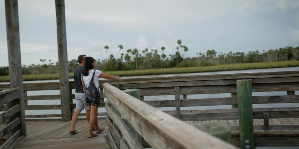 Man and woman walking on a pier
