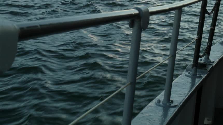 Side railing on a boat traveling in water