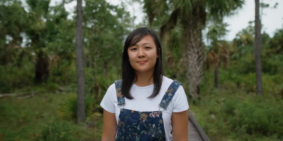 A woman is standing outdoors in a rainforest in spring