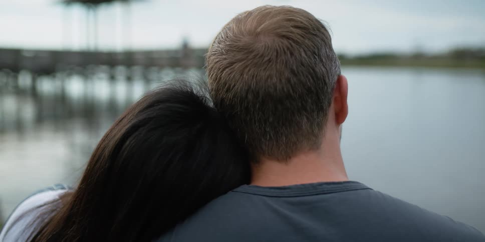 Husband and wife are relaxing by the lake together