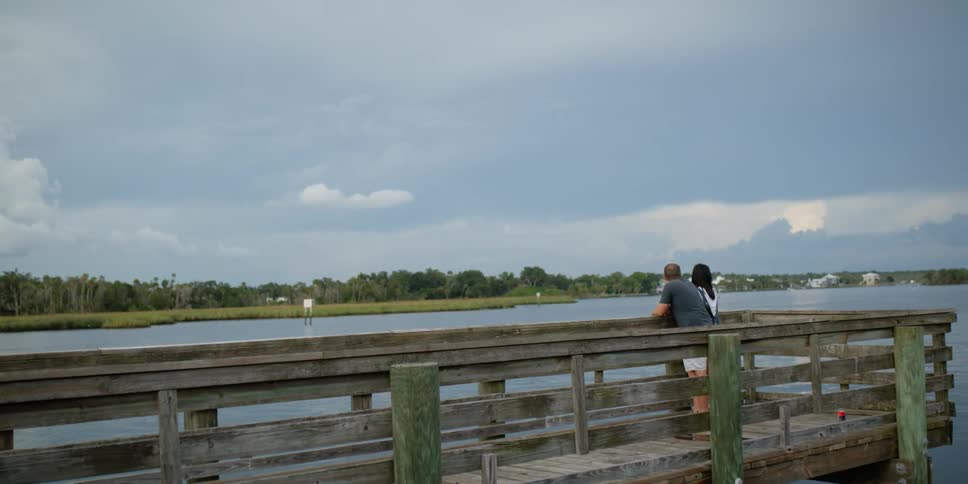 A couple stand on the pier together