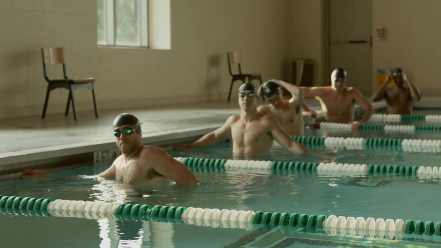 Swimmers are lining up in a pool for a race