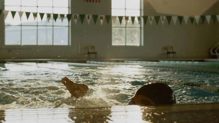 Two men swimming laps in an indoor pool