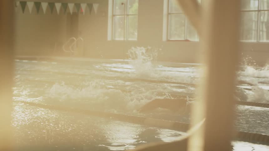 Swimmers start a race and swim the butterfly stroke to the other end of the pool