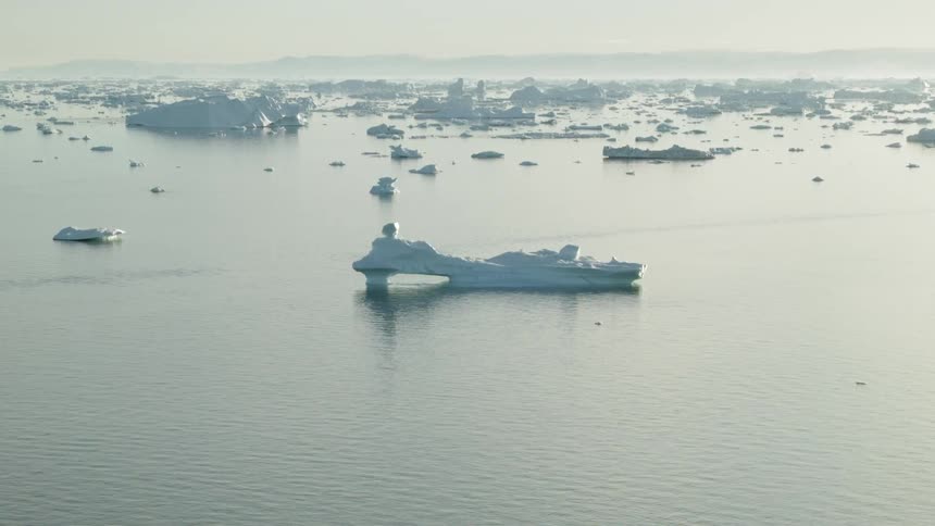 A body of water is full of icebergs