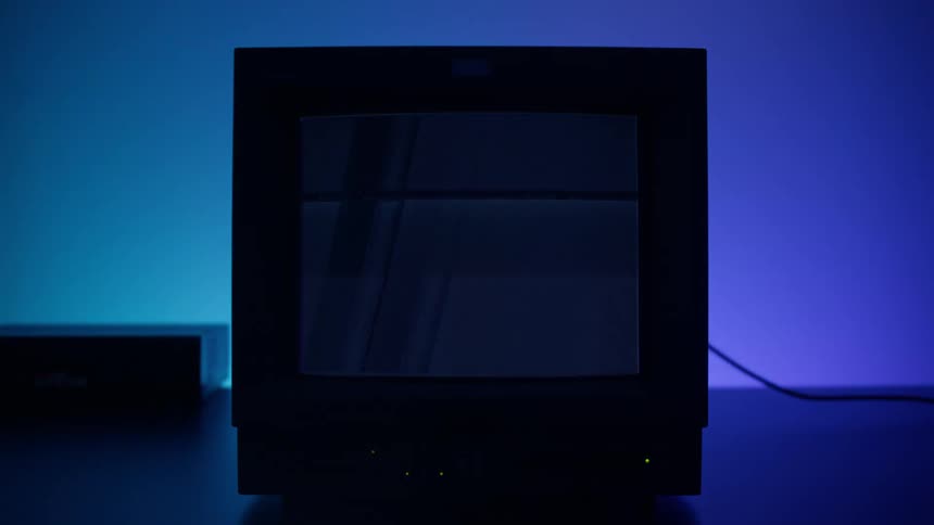 A small television displays flickering as rainbow colors glow from behind it