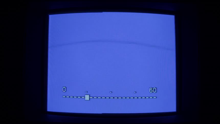 An old monitor flickers on and off while displaying a blue screen