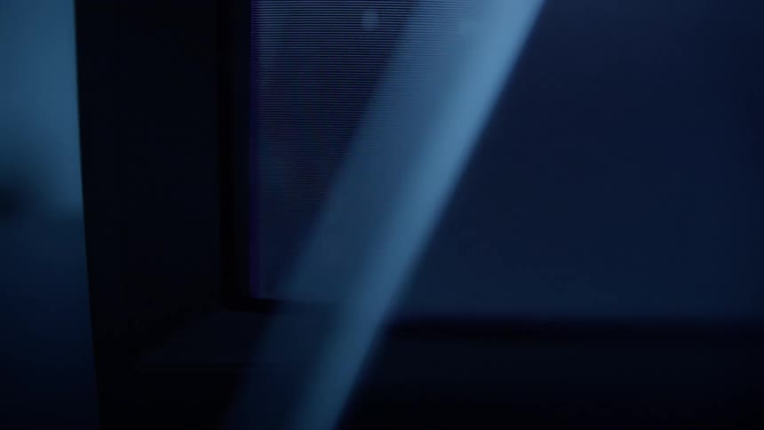 The television screen is flickering in the dark