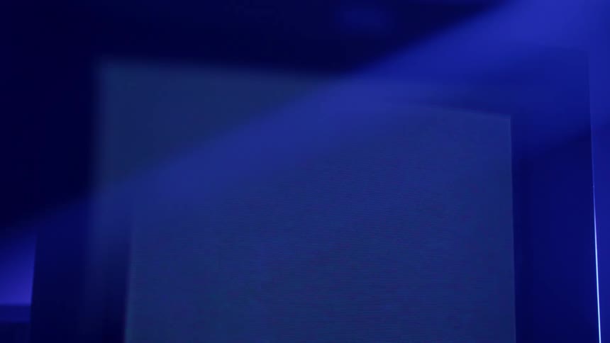A television playing static and lines with colorful lights shining on it