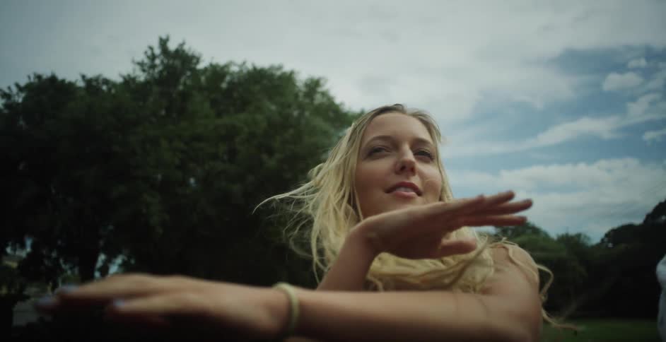 A blonde woman's hair moves in the wind