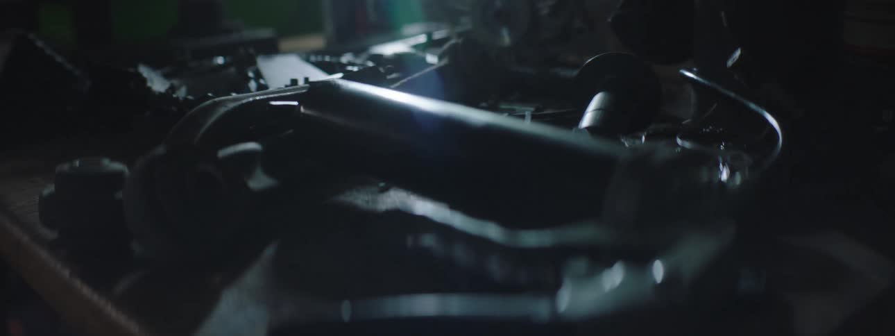 Mechanical spare parts over a table inside a dimly lit workshop
