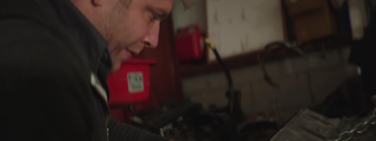 A man is working on a car in a garage