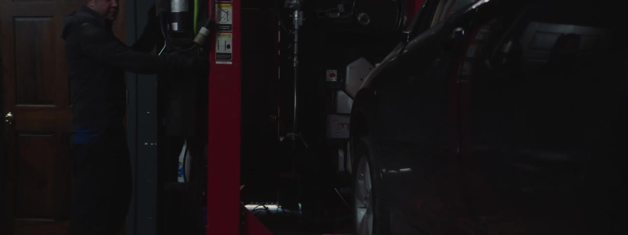 A mechanic raises a vehicle on the lift