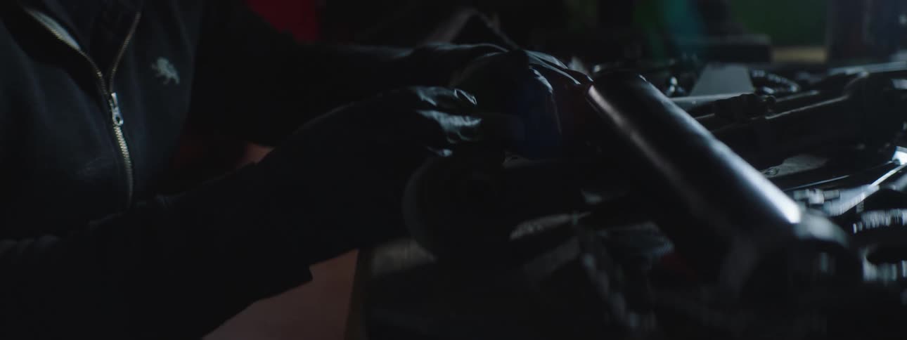 A person working on a car with gloves