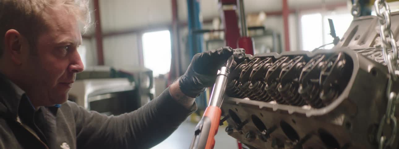 A man is working in a shop and using tools
