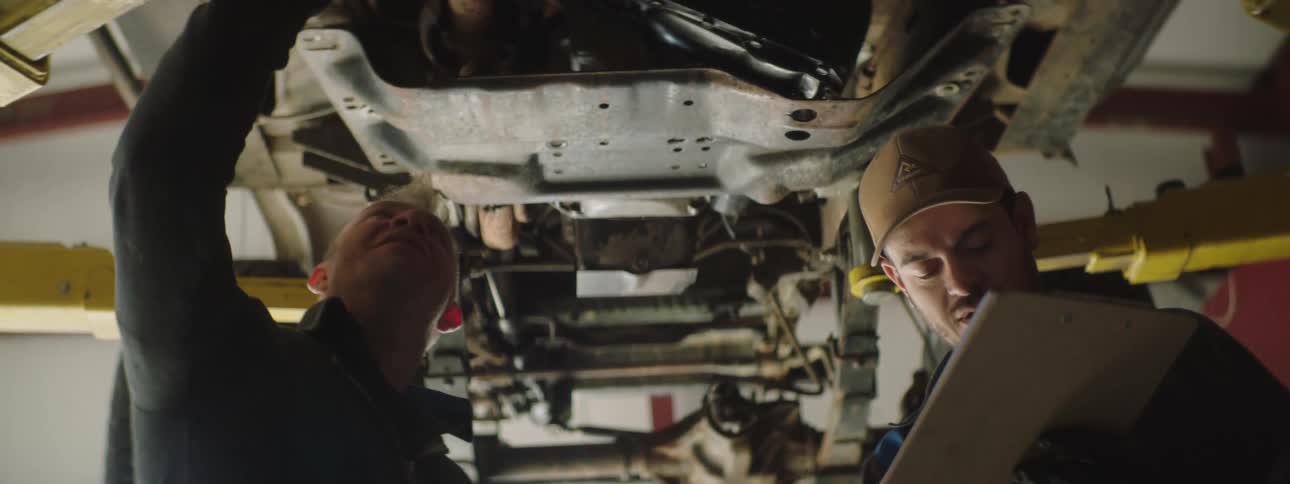Two employees working on a car