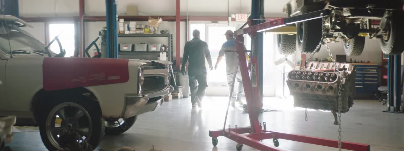 Two coworkers are leaving an automotive shop together