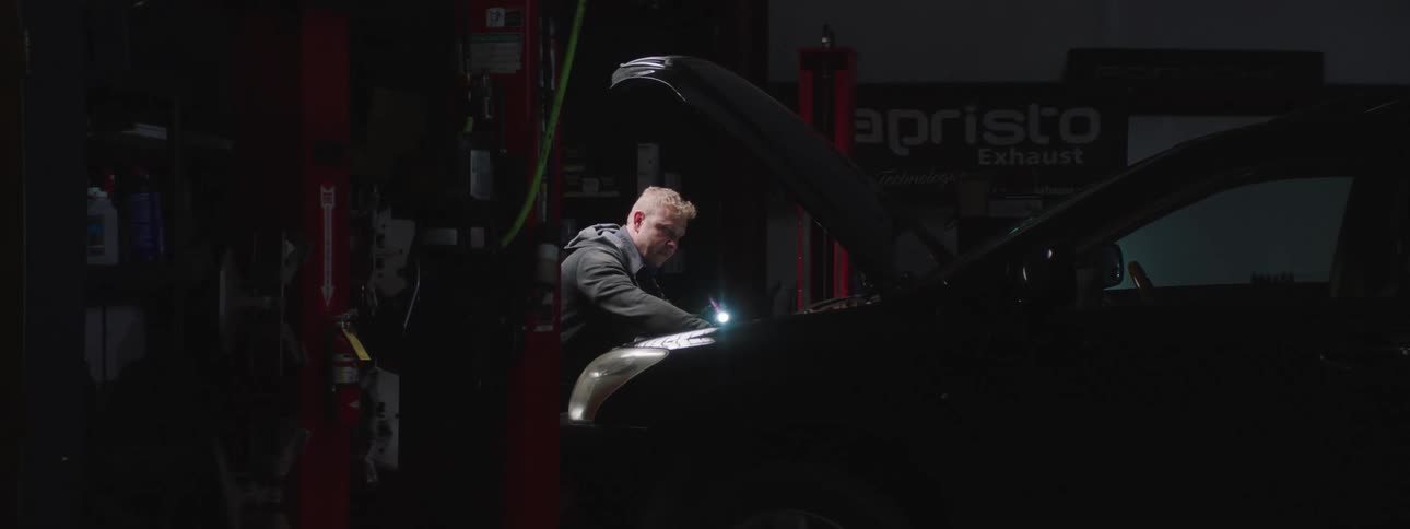 A man is working on a car in the auto shop