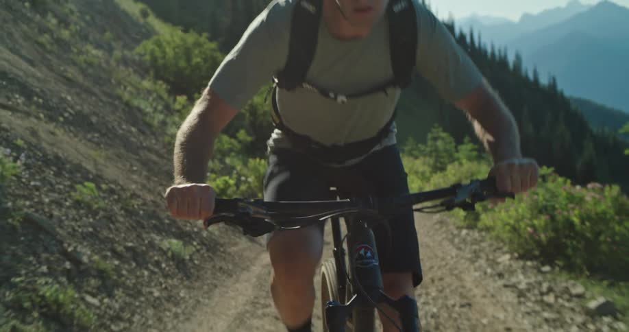 A man pushes hard riding his mountain bicycle up a steep incline