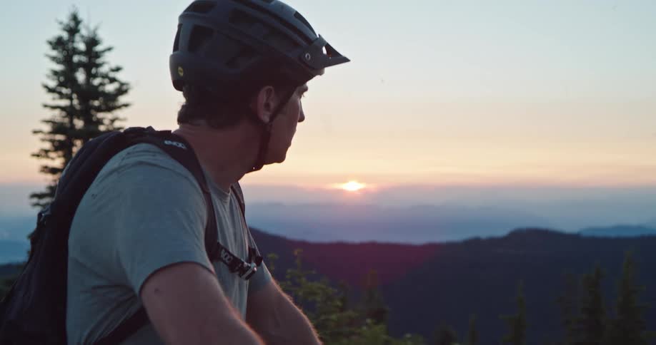 A cyclist catches his breath as he admires the view from a mountain summit