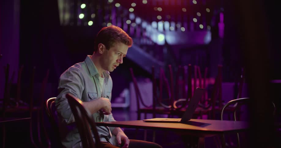 A man is sitting at a table with a laptop