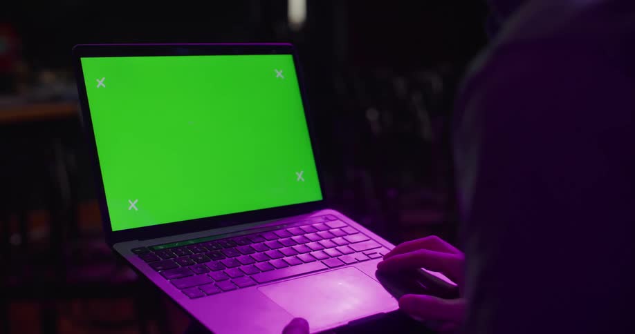 A person is looking at a laptop at night