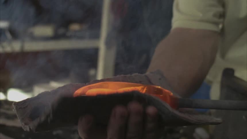 A person is spinning glass with tools