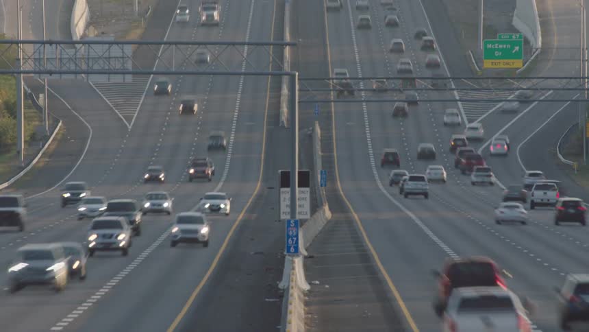 Cars and trucks travel on the divided highway
