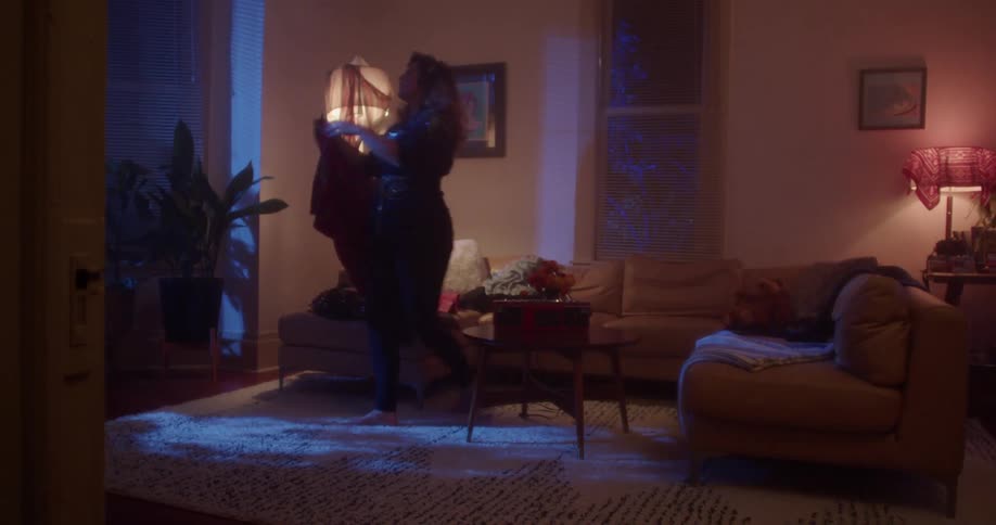 A woman checks out clothing in her living room