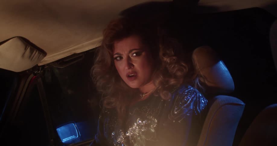 A woman sitting in a car singing