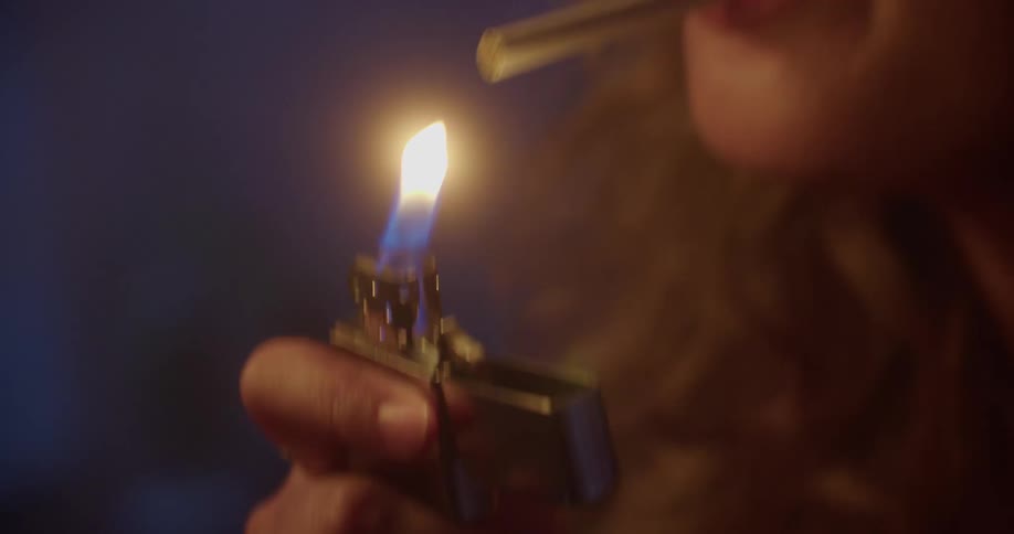Woman lighting cigarette with an old lighter